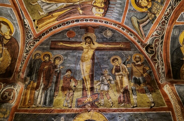 Karanlık Kilise’de yer alan çarmıha gerili İsa freski. İsa’nın iki yanında azizler, askerler ve yas tutan figürler görülüyor.